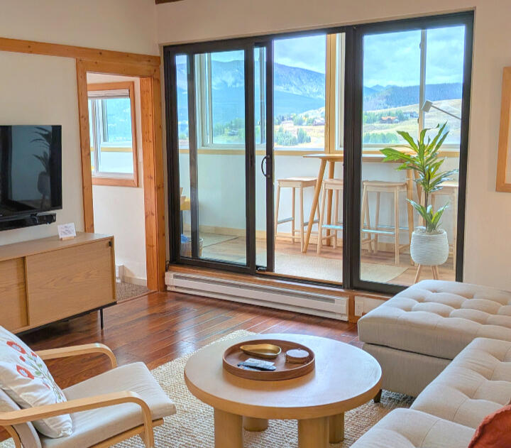 Mountain-Modern Living Room and Kitchen Open living room with couch, dining table, and kitchen in a two-bedroom Mt. Crested Butte condo rental